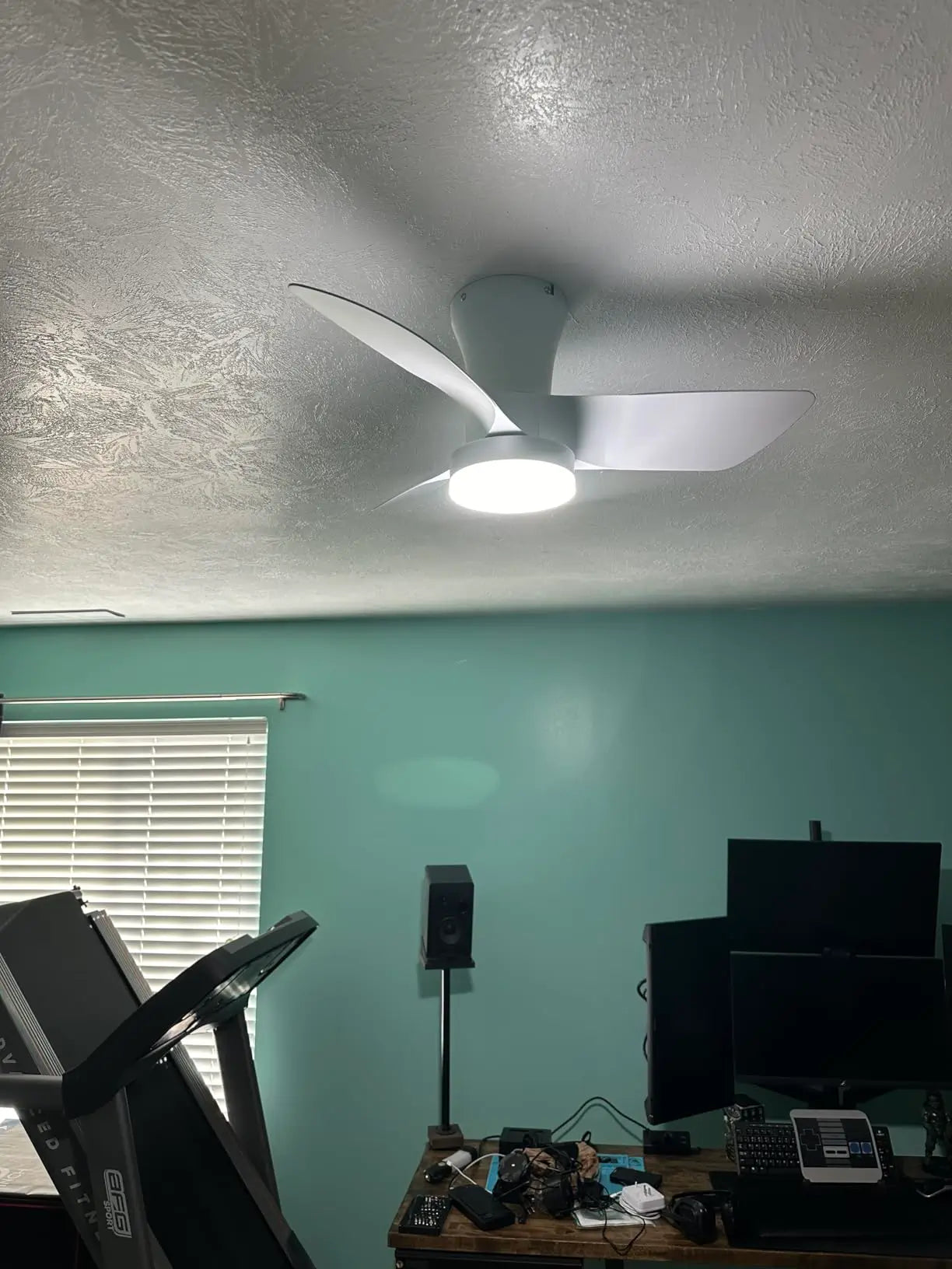 A dark, industrial-style ceiling fan with a matching light fixture, providing a bold statement piece for a bedroom or living area with its robust design.