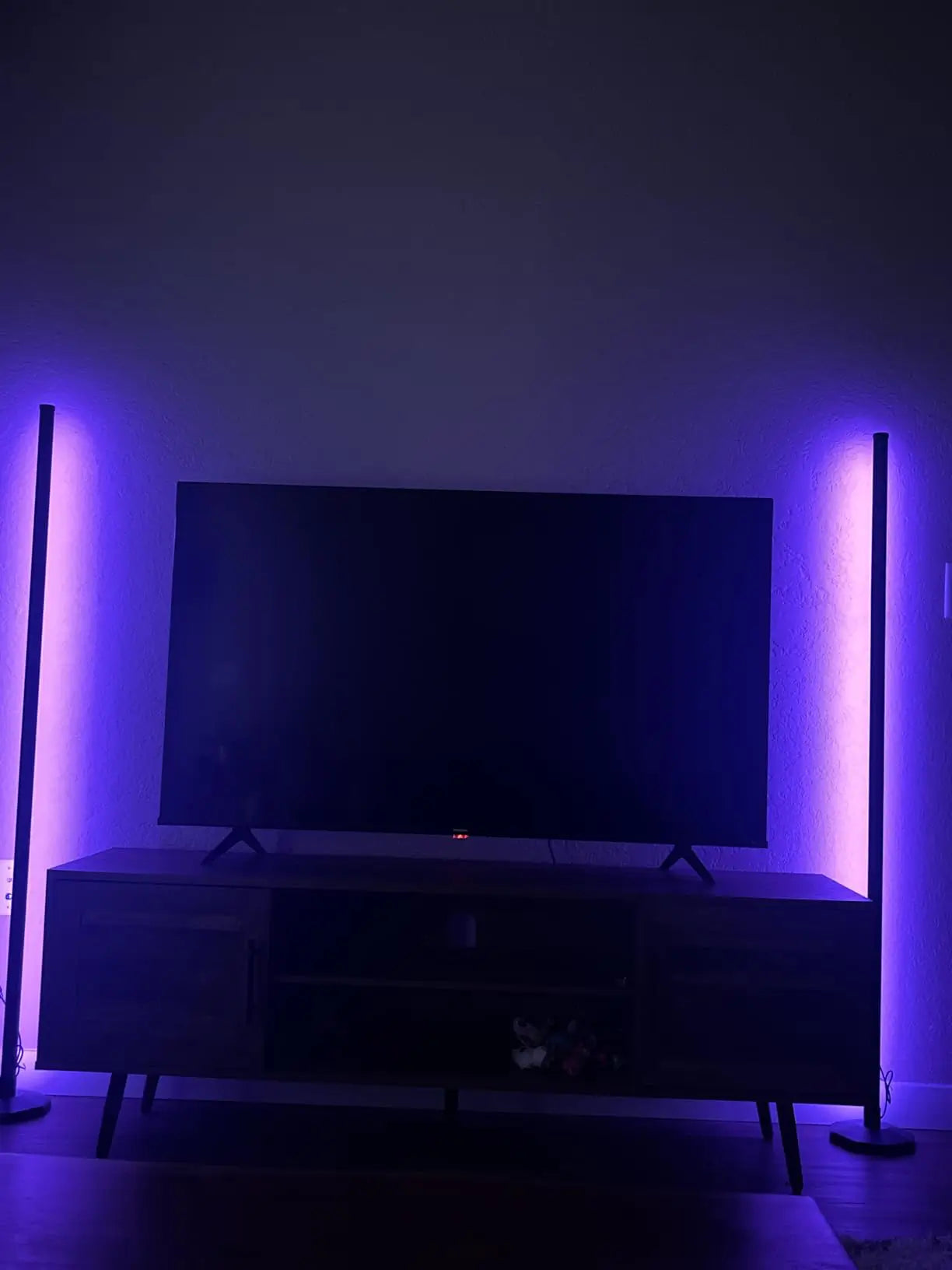 A modern RGB strip floor lamp creating vibrant backlighting behind a gaming or entertainment setup, adding an immersive colorful dynamic to the space.