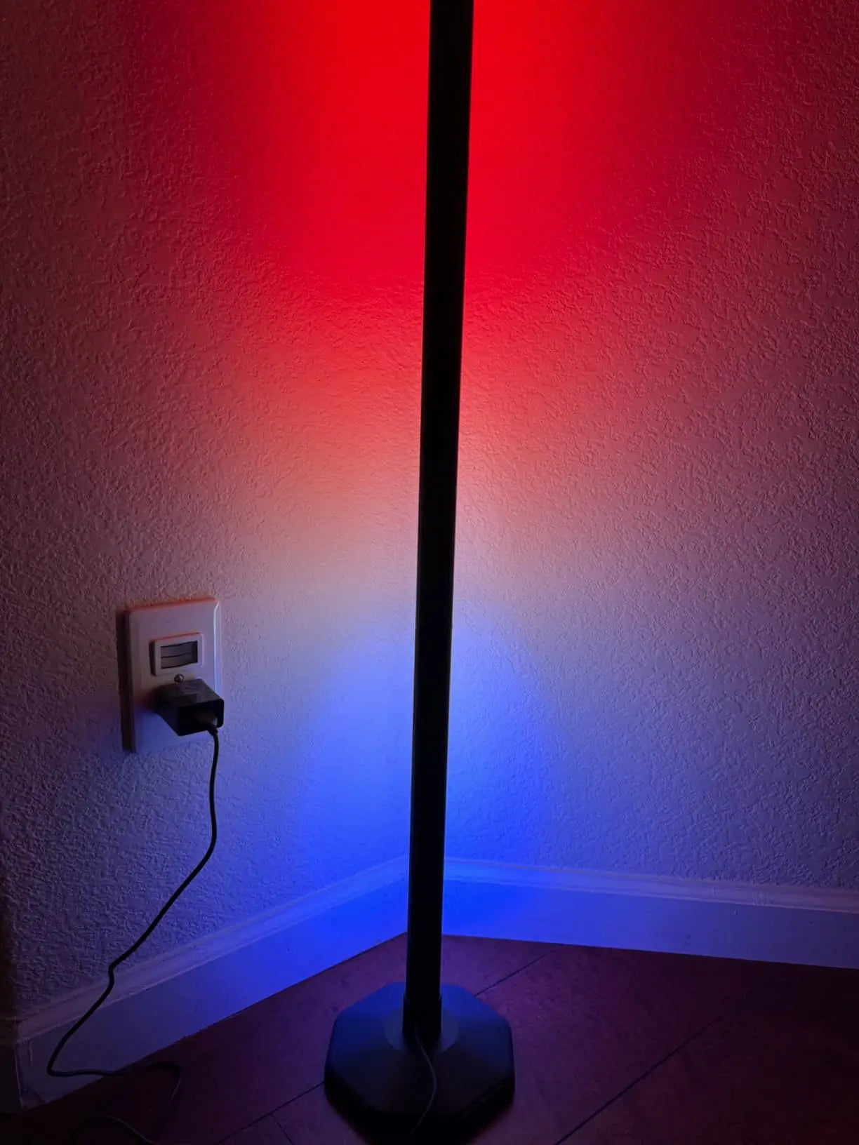A sleek, minimalist LED RGB floor lamp illuminating a clean, modern space with a subtle glow, demonstrating its versatile color-changing capabilities.