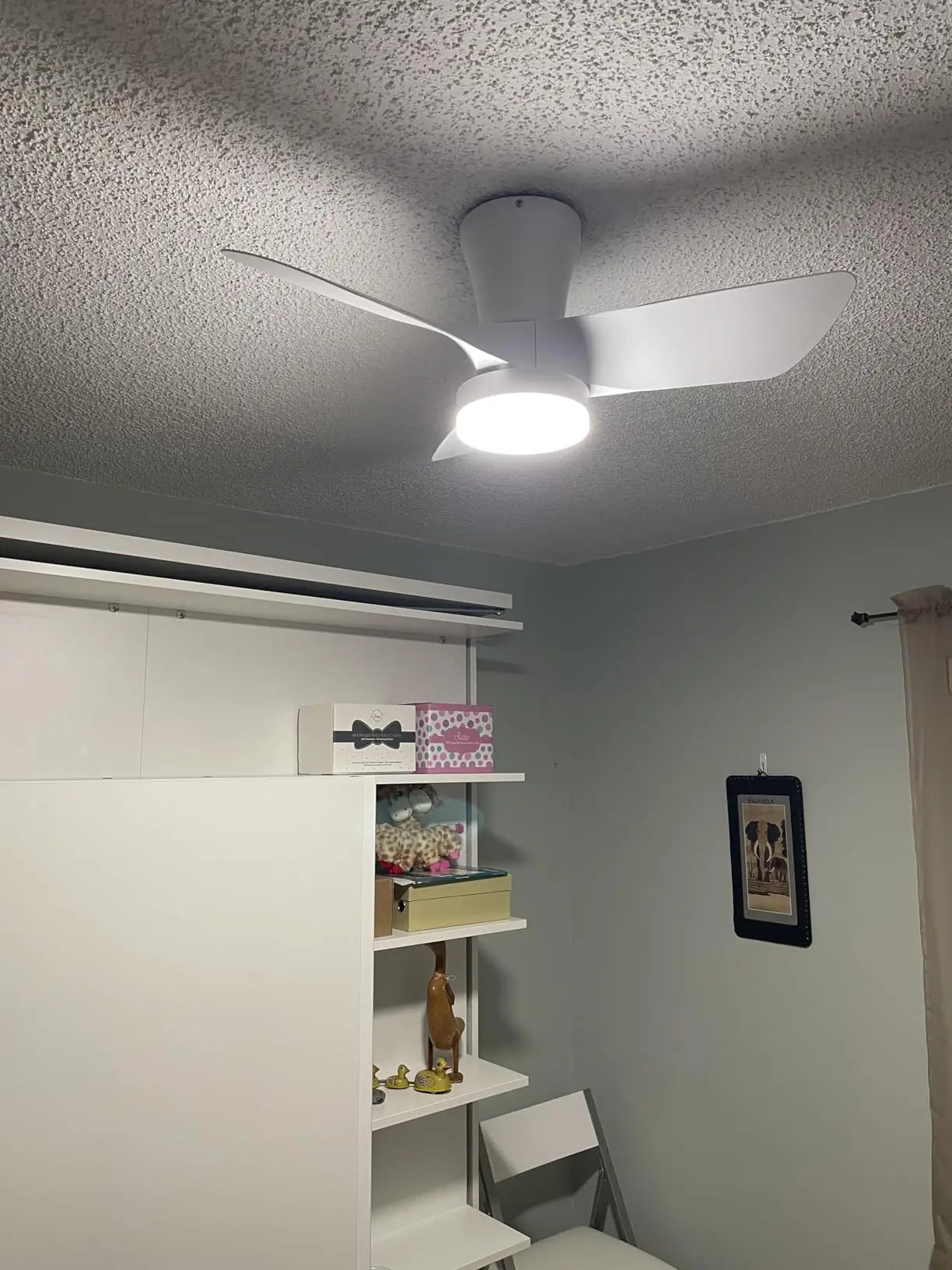 A low-profile ceiling fan with a compact design and integrated light, ideal for rooms with limited vertical space, providing efficient air flow and discreet lighting.