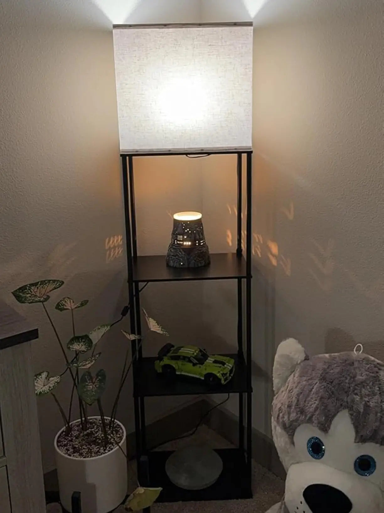 A modern black floor lamp with an adjustable, Lampshade with wood grain surface and storing space, providing focused task lighting for reading or accenting a contemporary living room.