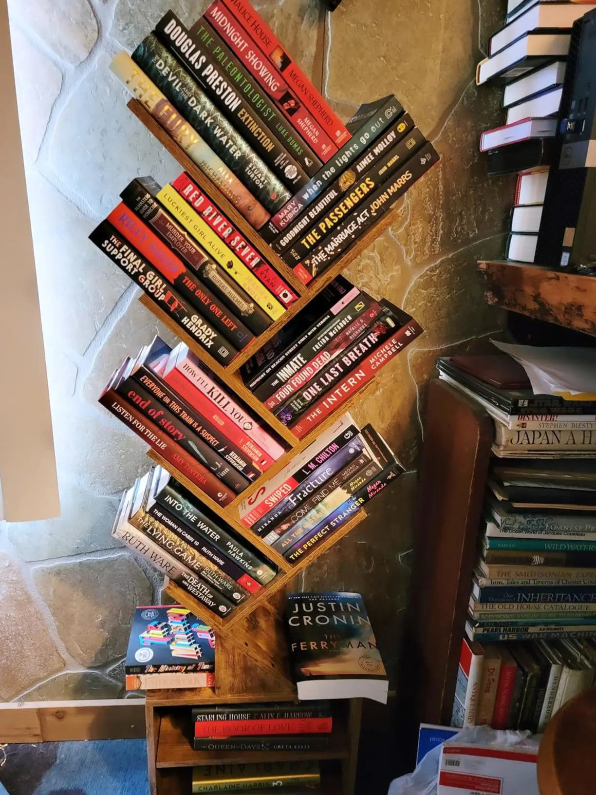 A modern tree bookshelf in a natural wood finish, filled with books, showcasing its unique branch-like design as a stylish and functional storage solution.