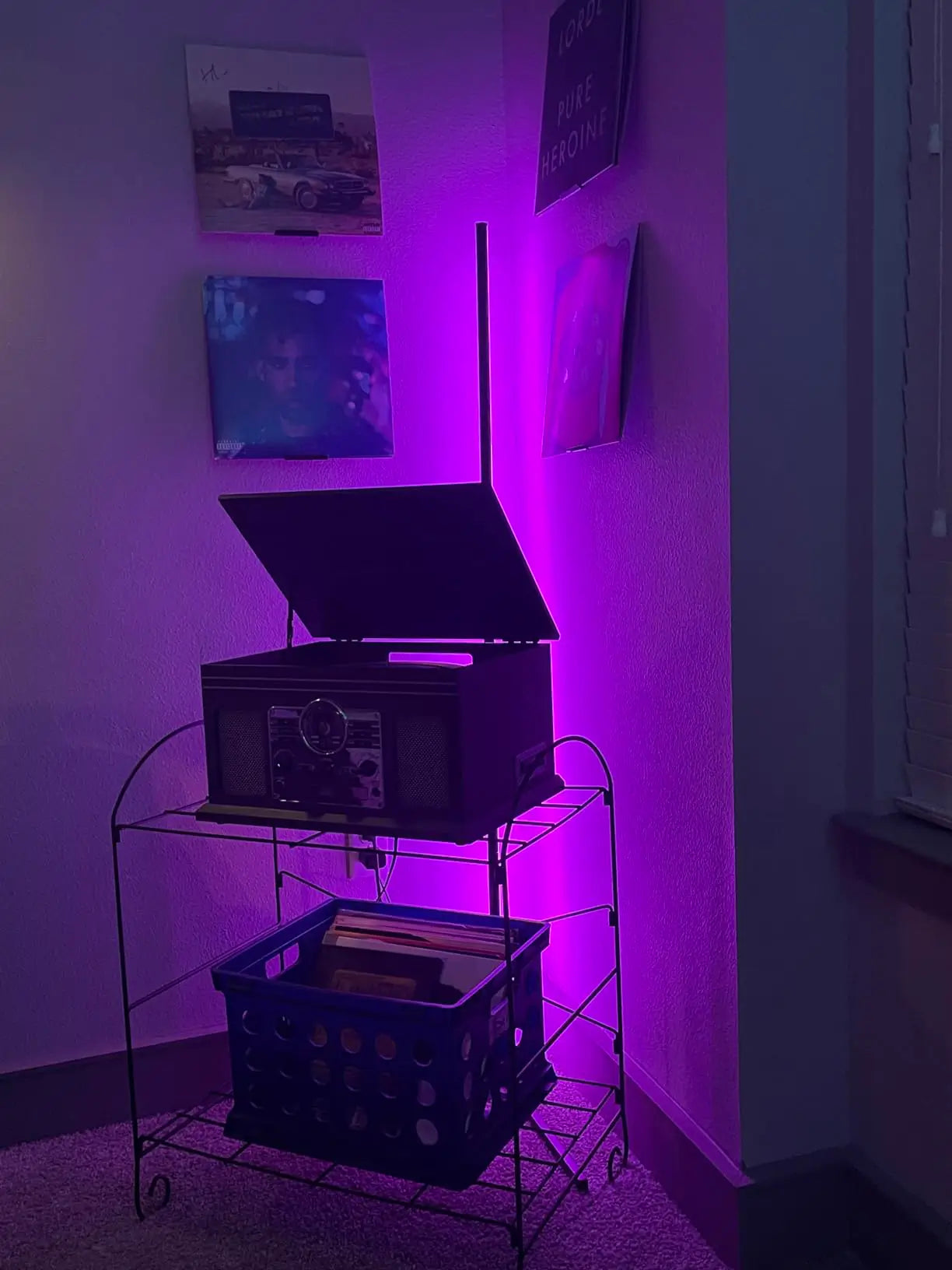 A tall corner RGB floor lamp casting a bright, colorful aura against a wall, effectively illuminating a room with customizable LED lighting effects.